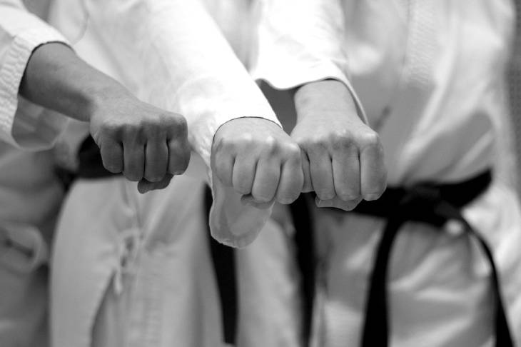 Photo of young kids holding fists together in karate